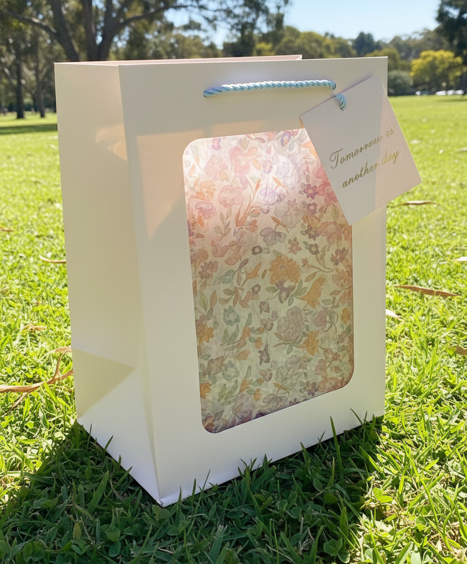 Gift bag with floral design and visible brand name on a white background